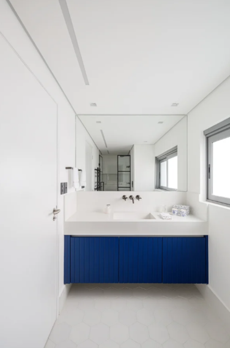 9. Armário de banheiro azul-marinho se destaca no décor clean e minimalista do banheiro – Projeto: Yannick Athia Arquitetura | Foto: @maxfahrerfotografia