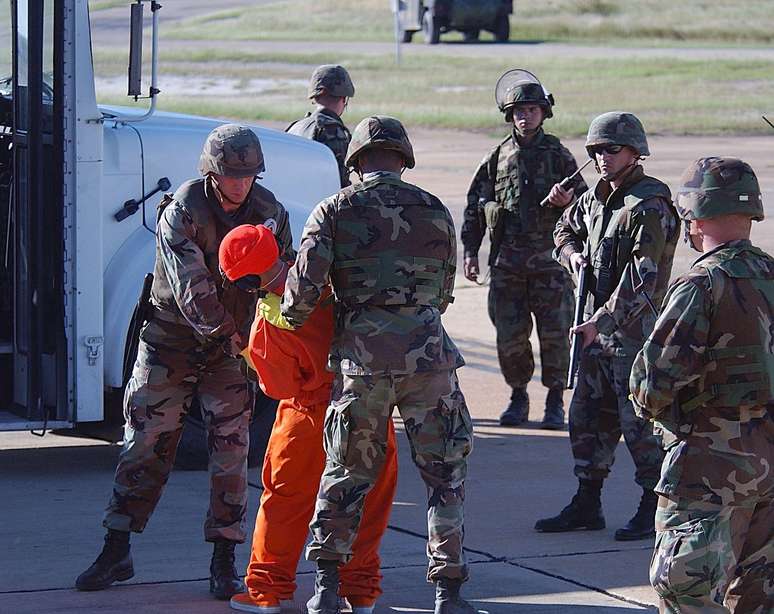 As imagens mostram a grande expectativa ao redor da chegada dos primeiros prisioneiros a Guantánamo. A transferência dos prisioneiros do avião para o ônibus que os transportaria para a prisão foi fortemente vigiada por fuzileiros navais prontos para agir