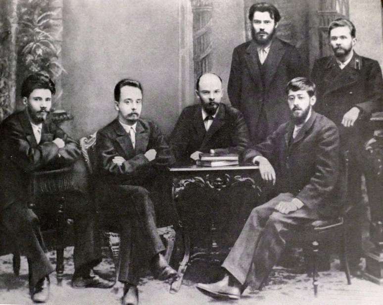Lênin (sentado no meio) junto a outros revolucionários russos. Entre eles, Yuli Martov (sentado à direita), que se tornou líder dos mencheviques
