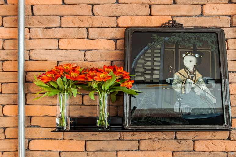Os quadros chineses dos moradores adornam a parede de tijolinhos, preservando memórias e valores singulares no lar Projeto do escritório Korman Arquitetos |