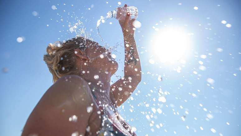mulher jogando água na cabeça em dia de calor