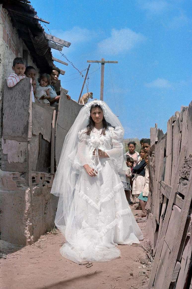 Na entrada do beco, Mari&acirc;ngela &eacute; observada com seu vestido de noiva