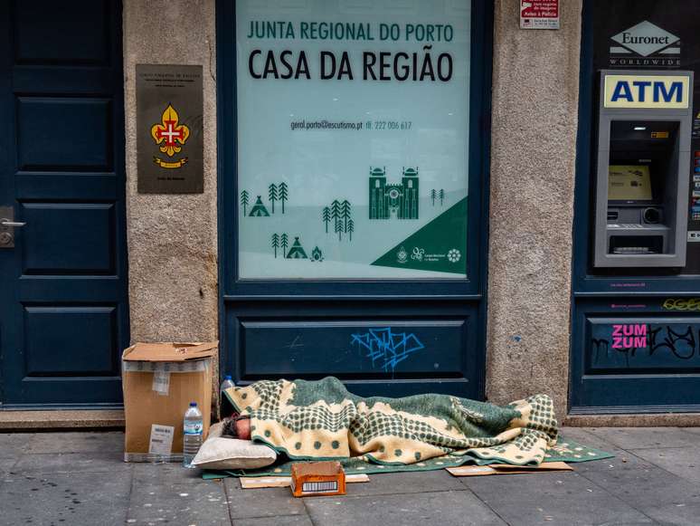 Pessoa dorme em rua da cidade de Porto, em Portugal