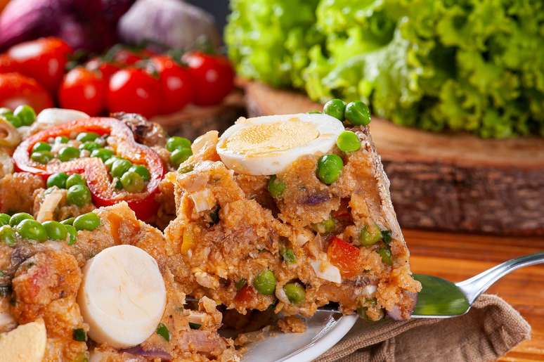 Fatia de um cuscuz paulista sendo cortada