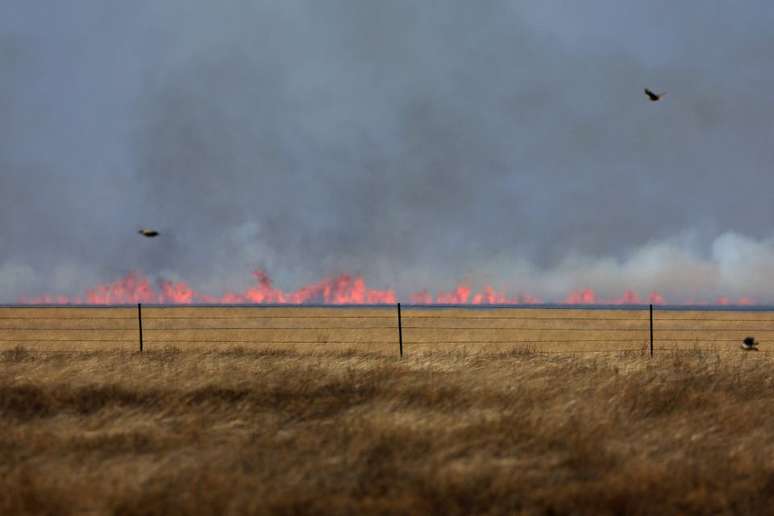 Incêndio florestal pode ser visto, levemente desfocado pelas ondas de calor, depois de ter sido fustigado por ventos fortes em Pampa, Texas 02/03/2024