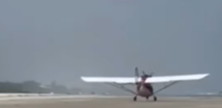 Beachgoers see the irregular landing of microlights on the beach in Bertioga, SP