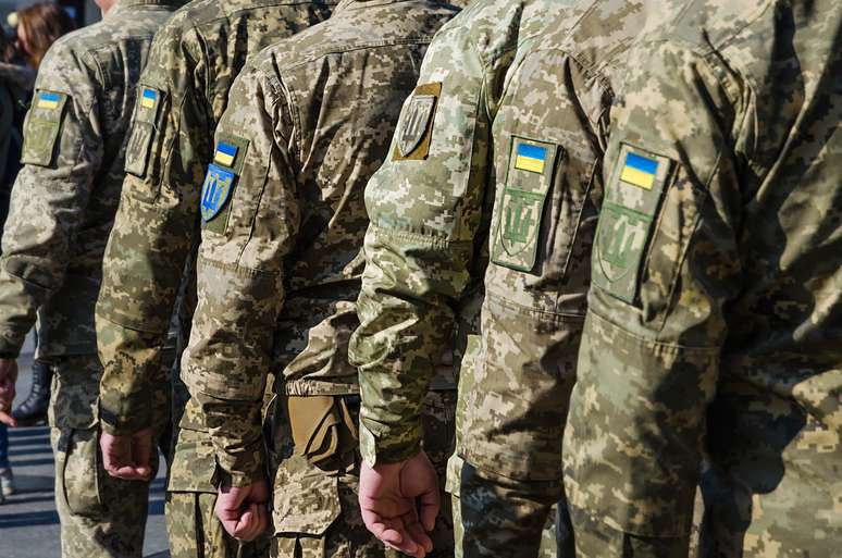 Soldados ucranianos em desfile militar. Bandeira ucraniana no uniforme militar
