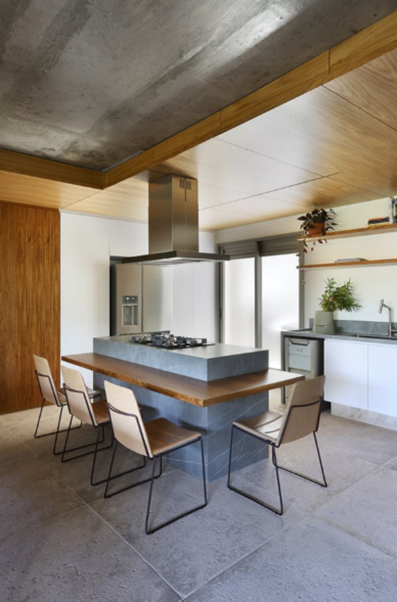 4. Cozinha moderna e minimalista com detalhes em concreto, madeira e ilha com cooktop e assentos elegantes – Projeto: Mandril Arquitetura | Foto: Fotógrafo Mariana Orsi @marianaorsifotografia