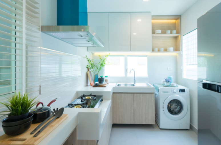20. Decoração para lavanderia pequena e simples integrada com cozinha com tons claros e amadeirados – Foto: Shutterstock