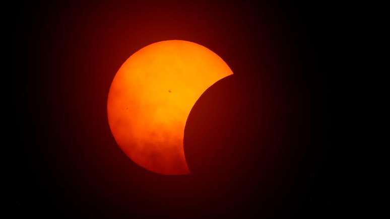 Foto tirada em Fort Worth, cidade americana no Texas, mostra a Lua começando a eclipsar o Sol