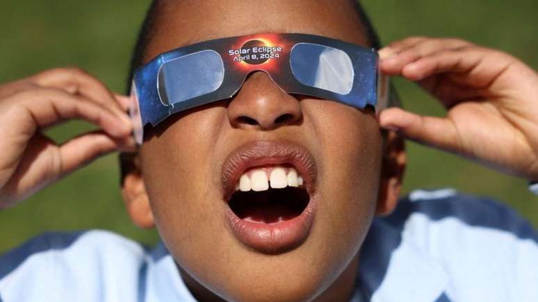 Este pequeno observador do céu testou seus óculos de eclipse no New York Hall of Science, no bairro do Queens, em Nova York (EUA)