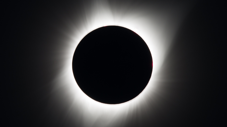 Durante o pico da totalidade do eclipse solar, a coroa solar pode se destacar na forma de um halo branco (Imagem: Reprodução/NASA/Aubrey Gemignani)