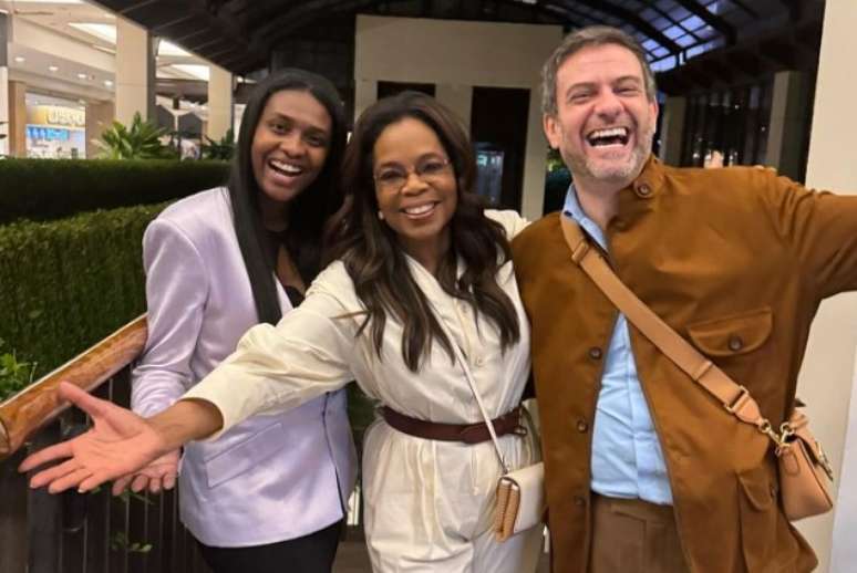Oprah Winfrey entre a relações-públicas do Cidade Jardim, Karine Amancio Pasqualucci, e o diretor criativo do centro de compras de luxo, Bruno Astuto