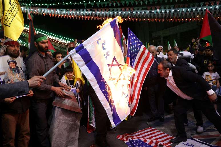 Manifestantes queimam bandeiras dos EUA e de Israel durante um protesto em Teerã, Irã, 1º de abril de 2024