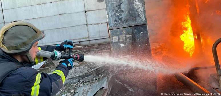 Bombeiro tenta conter o fogo em usina após bombardeio russo