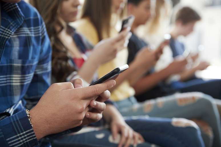 Estudantes do ensino médio usam telefones celulares em escolas