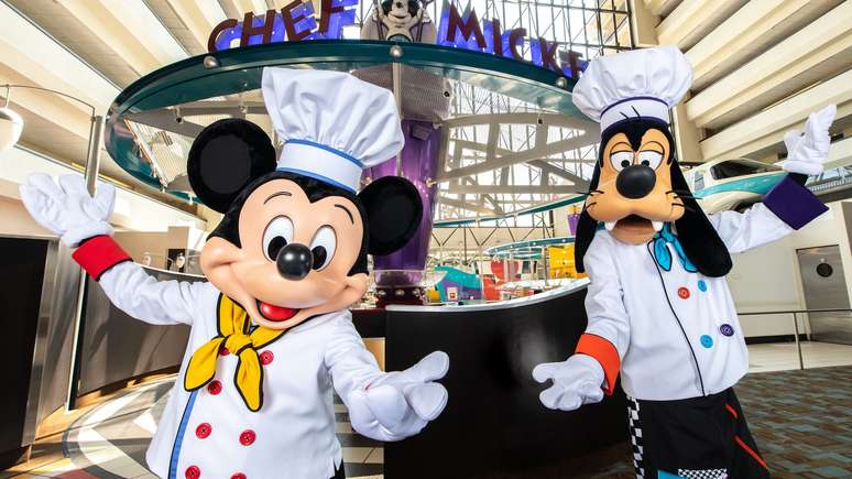 Mickey e Pateta vestidos de chefs de cozinha recepcionam os visitantes