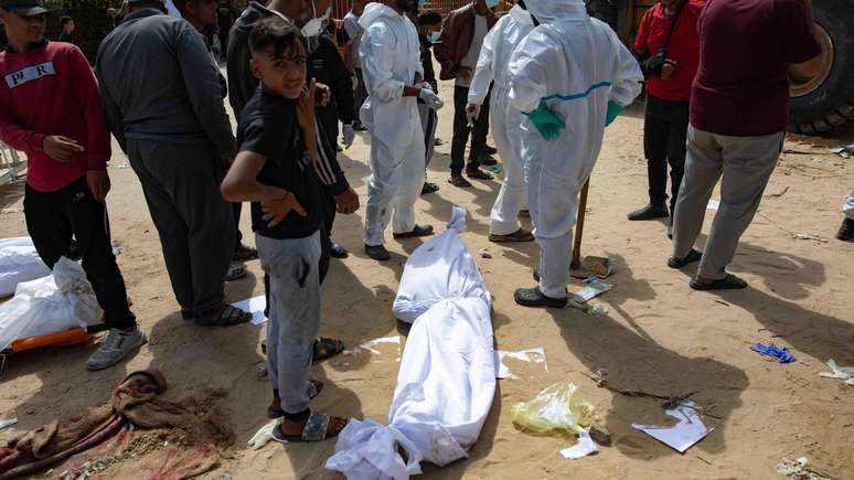 Corpos em mortalhas jazem no chão do hospital Nasser