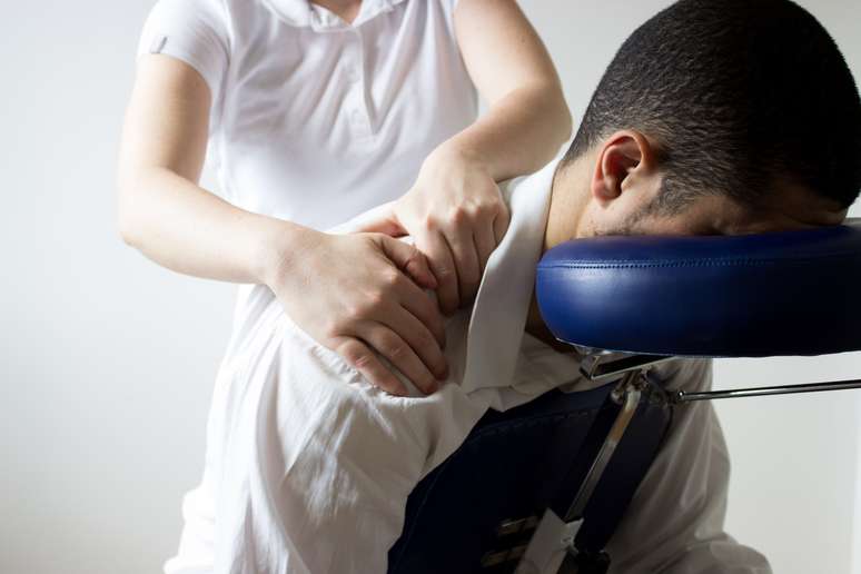 Homem recebe shiatsu na cadeira da massagem