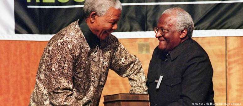 Em registro histórico de 1998, o arcebispo Desmond Tutu, presidente da comissão da verdade sul-africana, entrega os relatórios do grupo ao presidente Nelson Mandela