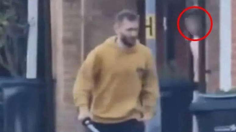 Imagens capturadas por vídeo mostram homem com espada. Ao fundo, uma das testemunhas que escapou do ataque