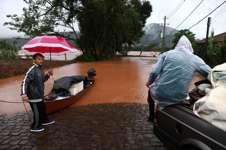 Pessoas resgatam seus pertences perto de área alagada próxima ao rio Taquari durante fortes chuvas na cidade de Encantado, no Rio Grande do Sul