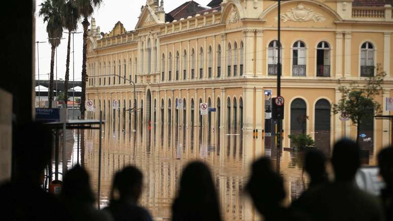 Moradores de Porto Alegre observam Mercado Público inundado, em foto de 4 de maio