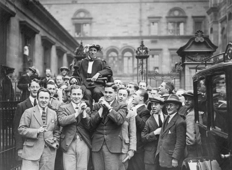 O atleta escocês Eric Liddell desfila carregado por colegas estudantes pela Universidade de Edimburgo após retornar dos Jogos Olímpicos de 1924