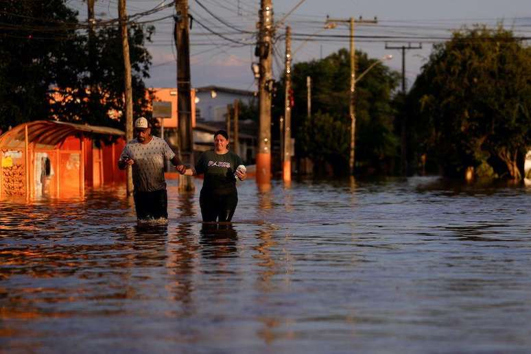 Pessoas caminham em um bairro em Canoas no domingo (5/5)