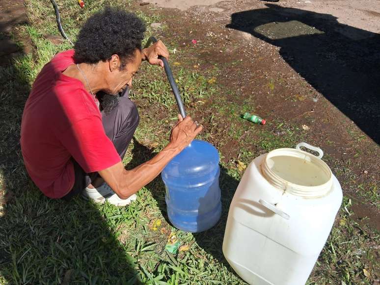 Alex Pantera conseguiu 40 litros de água na bica do Morro Santana. Vai levar os dois recipientes para o morro ao lado, Bom Jesus
