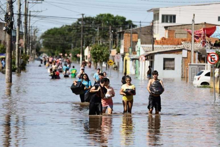 Moradores de Eldorado do Sul carregavam pertences em rua alagada