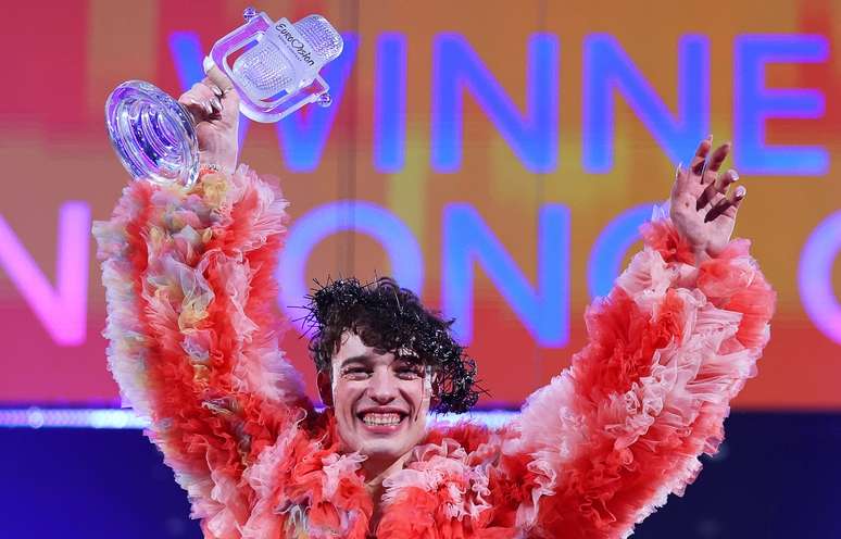 O cantor suíço Nemo com o belo troféu de cristal em formato de microfone antigo do Eurovision