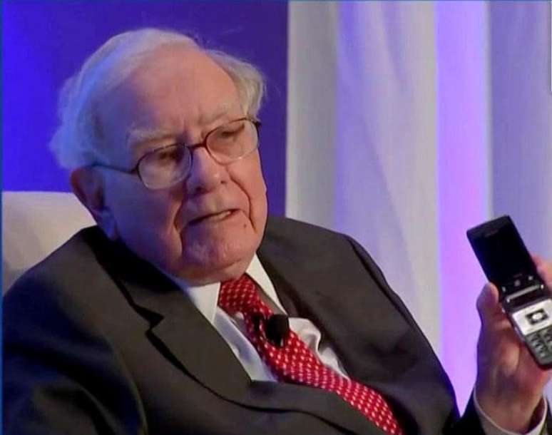 O megainvestidor Warren Buffett mostra o aparelho celular básico que ainda usa