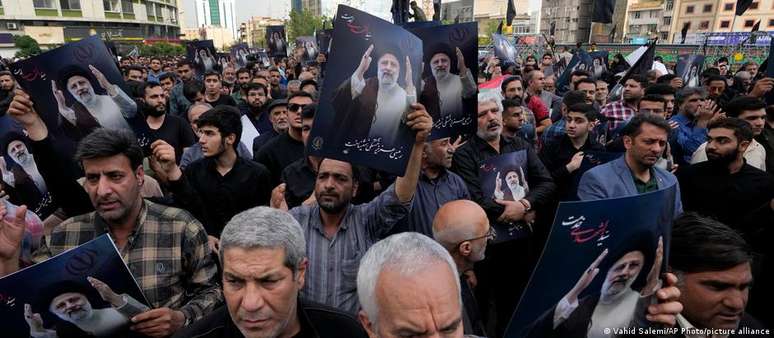Homens iranianos em cerimônia fúnebre para o presidente Ebrahim Raisi, morto em acidente de helicóptero
