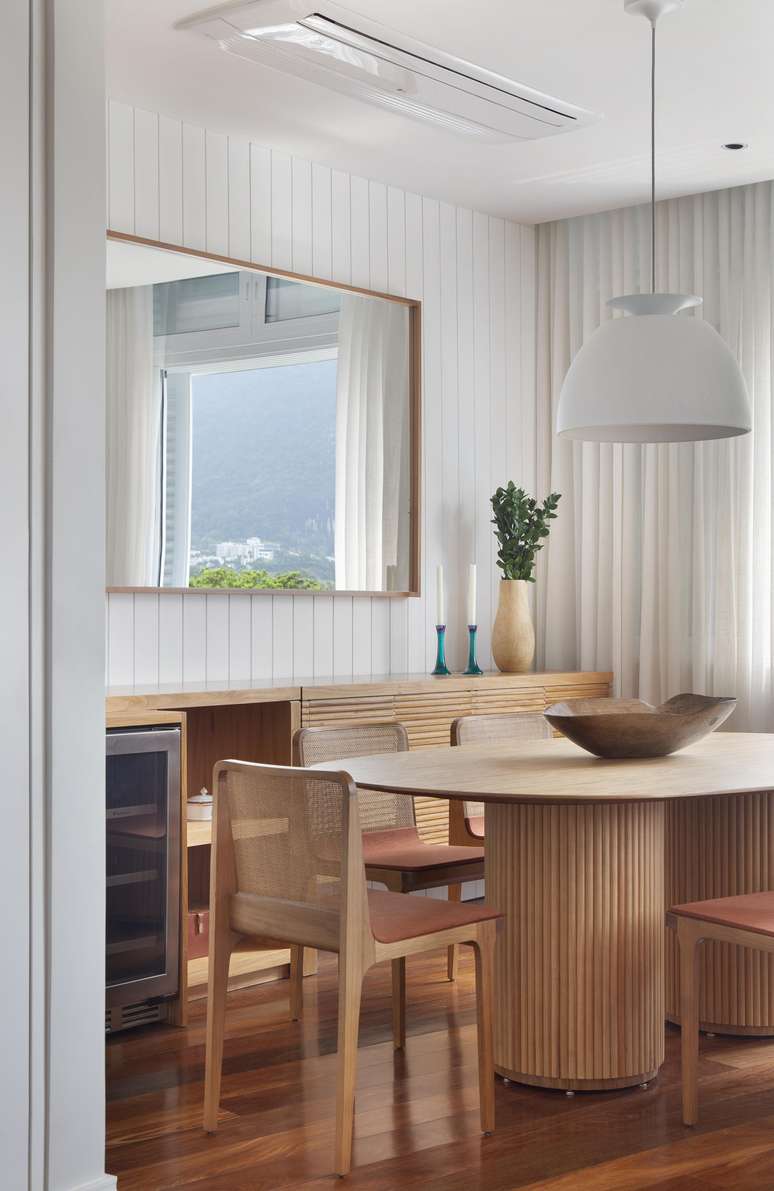 Neste outro projeto, arquitetas Daniela Miranda e Tatiana Galiano aproveitaram um buffet em laca para completar a sala de jantar composta por madeira de tonalidade clara | Projeto da Memoá Arquitetos.