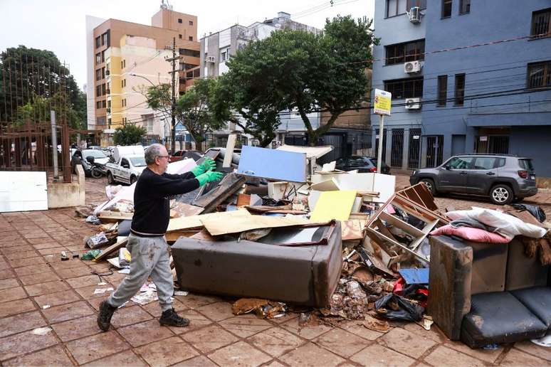 Um homem descarta objetos afetados pela enchente em sua casa em Porto Alegre, Rio Grande do Sul (20/05/2024)