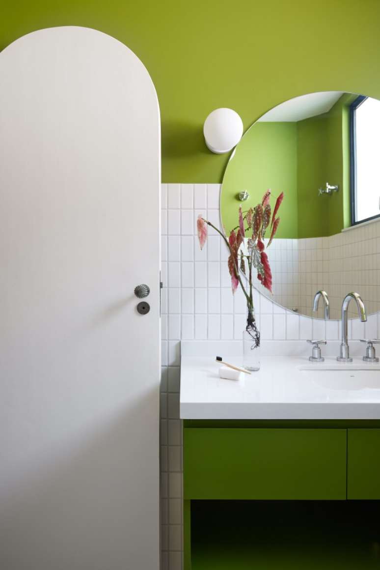Porta de serralheria vira luminária pendente em cobertura com parrilheira. Projeto de Hugo Rapizo Arquitetura. Na foto, banheiro, porta arco, parede verde.