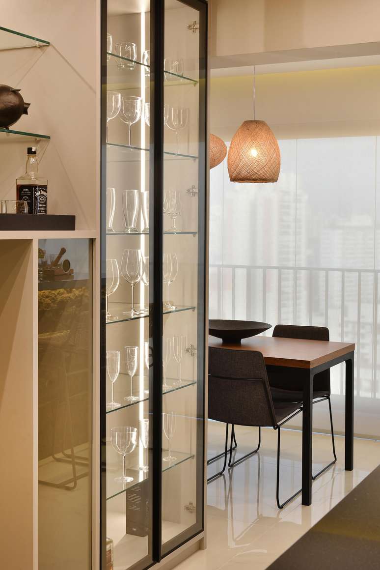 Nesse projeto realizado pela arquiteta Rosangela Pena, a versão de serralheria e vidro, iluminada por LED, está ao lado do cantinho do bar e próxima à varanda.