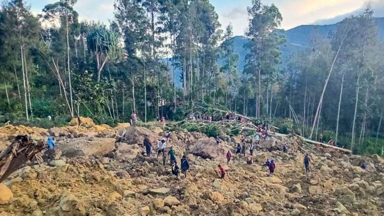 Pessoas se reúnem no local de um deslizamento de terra em Maip Mulitaka, na província de Enga, Papua Nova Guiné, em 24 de maio de 2024.
