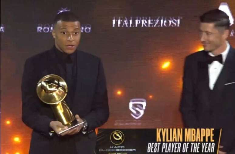 Reprodução - Legenda: Mbappé com o prêmio de melhor jogador do mundo entregue no Globe Soccer Awards -