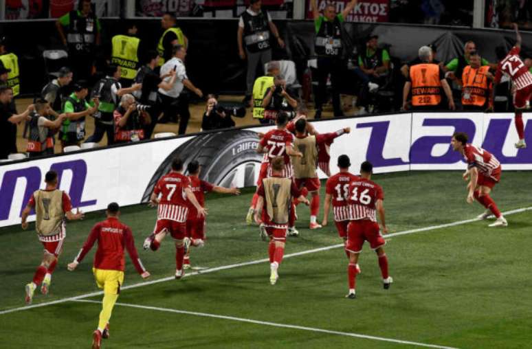 Theophile Bloudanis/AFP via Getty Images - Legenda: Jogadores do Olympiacos comemoram o gol do título da Liga Conferência -