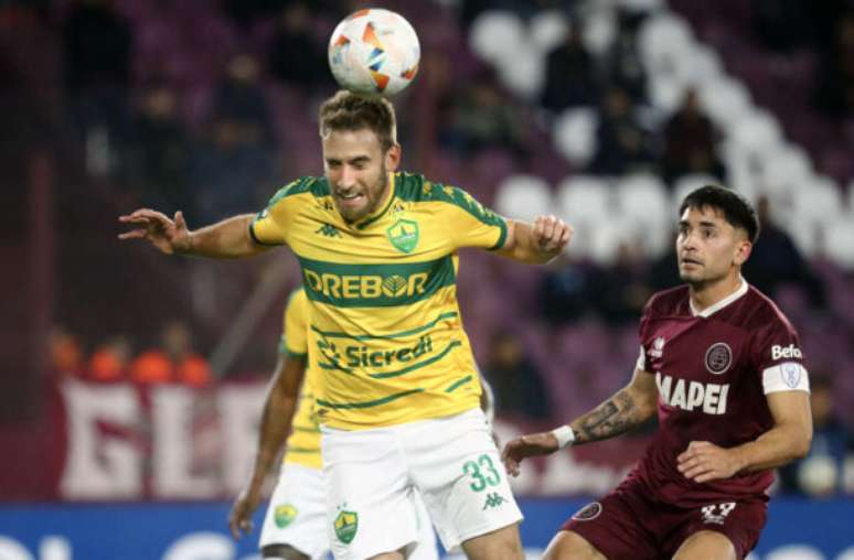 Marcos Brindicci/AFP via Getty Images - Legenda: Jogadores de Cuiabá e Lanús em disputa de bola na Sul-Americana -