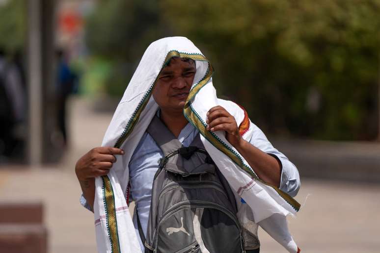 Um homem cobre a cabeça com um pano para se salvar da onda de calor em curso, em um dia quente de verão em Nova Delhi, Índia, em 29 de maio de 2024