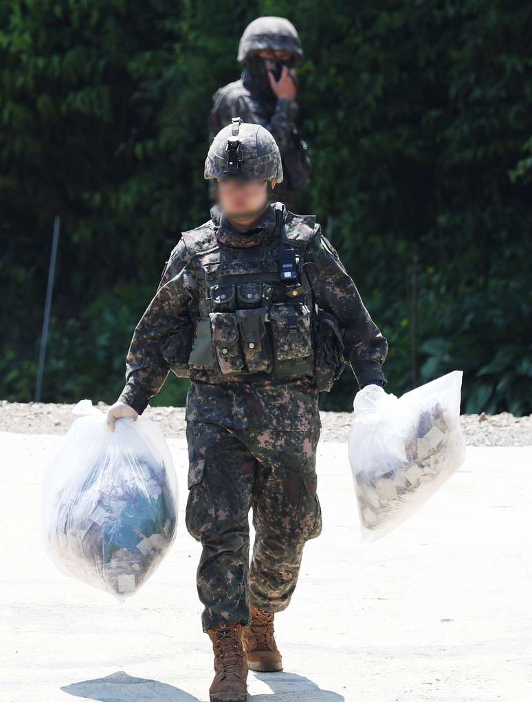Soldados recolhem sacolas encontradas em uma colina em Pyeongtaek, na Coreia do Sul