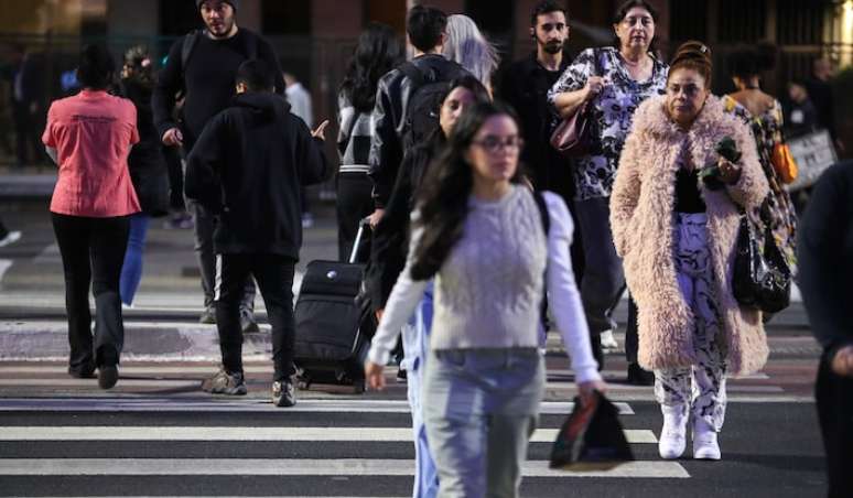 Pedestres andam agasalhados em dia de temperatura baixa na Avenida Paulista, na cidade de São Paulo.