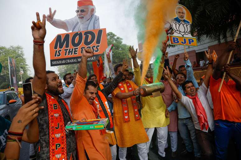 Apoiadores do Partido Bharatiya Janata (BJP) comemoram do lado de fora da sede do BJP, no dia dos resultados das eleições gerais, em Nova Delhi