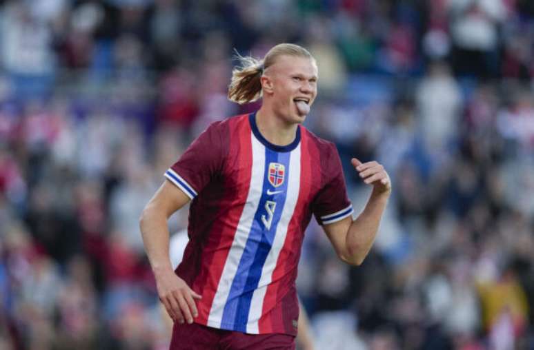 Fredrik Varjell/AFP via Getty Images - Legenda: Haaland em disputa de bola com jogadores de Kosovo -
