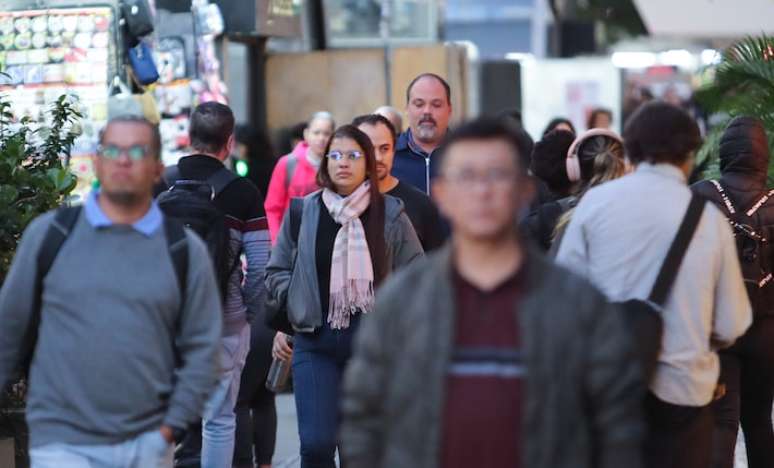 Pedestres andam agasalhados em dia de temperatura baixa na Avenida Paulista na cidade de São Paulo.