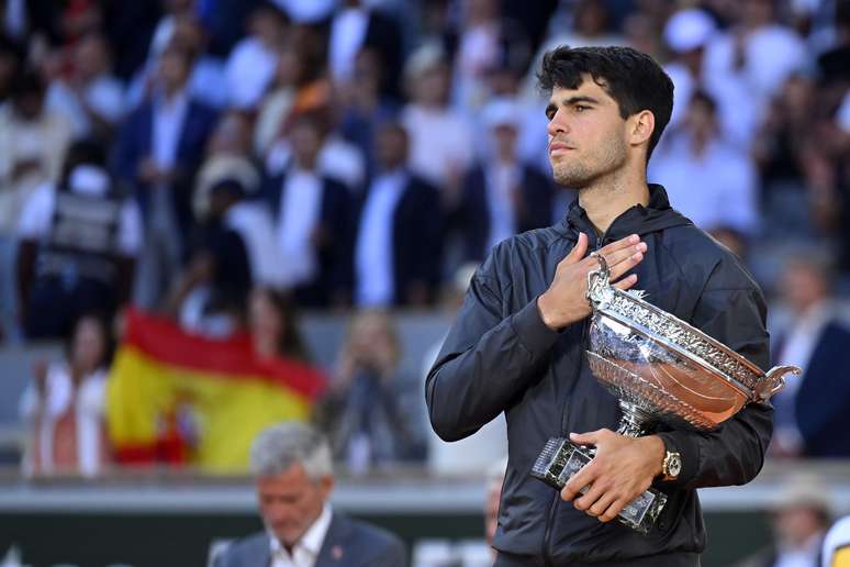 Carlos Alcaraz, da Espanha, segura troféu de campeão conquistado em Roland Garros.