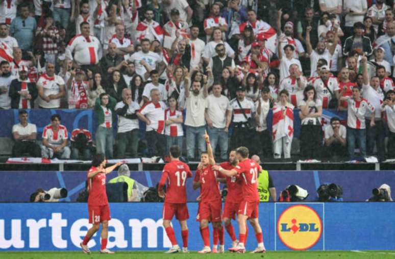 Kenzo Tribouillard/AFP via Getty Images - Legenda: Jogadores de Turquia e Geórgia em disputa de bola na Euro 2024 -